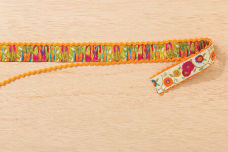 orange rickrack being glued to the back side of floral ribbon